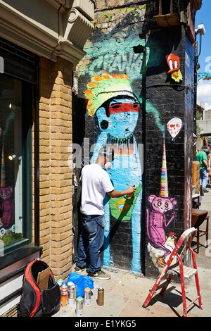 Artiste graffiti peint le mur sur Brick Lane sur Juin 06, 2014 à Londres. Banque D'Images