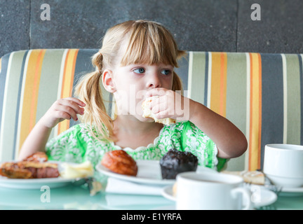 Cute little girl eating breakfast Banque D'Images