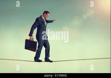 Homme courageux en équilibre sur une corde raide ou highwire Banque D'Images