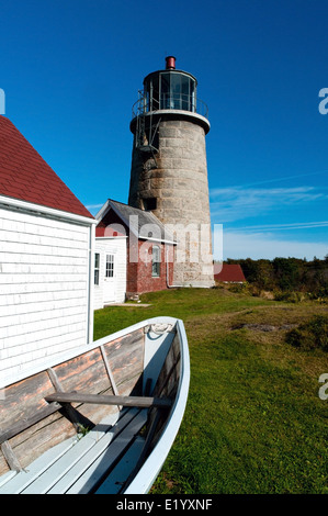 L'île Monhegan phare en pierre est un sujet de prédilection pour les artistes du monde entier. Chaloupe a été placé à proximité par des artisans. Banque D'Images