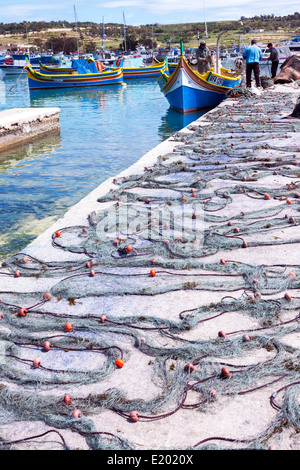 Bateaux de pêche en bois avec des filets disposés sur le quai dans le port de Marsaxlokk, Malte, Banque D'Images