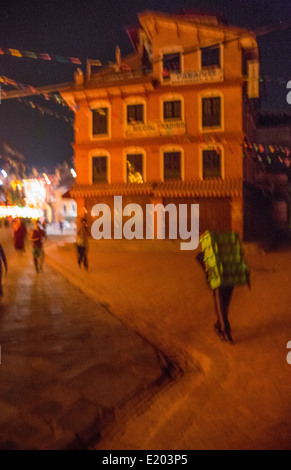 Katmandou Népal un porteur au petit matin sa charge toting autour du stupa de Boudhanath, Banque D'Images