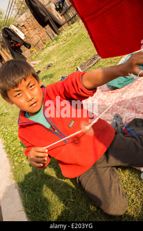 Katmandou Népal Nepali garçon jouet spinning wheel dans Nayapati, l'Est de Katmandou 1 Banque D'Images