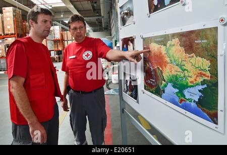 Schönefeld, Allemagne. 12 Juin, 2014. Partisans Armin Freistedt (L) et Uwe Steinke de la Croix-Rouge allemande d'examiner une carte avant le départ du convoi d'aide de la Croix Rouge à l'Ukraine, à la Croix-Rouge centre logistique à Schönefeld, Allemagne, 12 juin 2014. Le convoi se compose de deux semi-remorques, trois cars, deux camions de 12 tonnes, un camion de 7,5 tonnes et une ambulance pour le transport des brancards, casques, sacs à dos de premiers soins, des couvertures, des tentes, des mannequins pour des cours de premiers soins ainsi que des fauteuils roulants et aides à la marche pour les personnes âgées. Dpa : Crédit photo alliance/Alamy Live News Banque D'Images