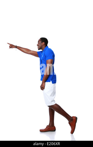 Vue de côté portrait of happy african man du doigt quelque chose sur fond blanc Banque D'Images