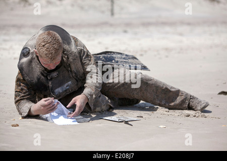 Un commando de reconnaissance de l'US Marine simule un rapport plage après avoir mené un canard dur l'insertion à Onslow Beach le 4 juin 2014 au Camp Lejeune, N.C. Un disque implique la suppression d'une insertion de canard entièrement gonflé en bateau en caoutchouc avec des marines dans l'eau depuis un hélicoptère. Banque D'Images