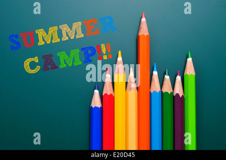 Camp d'été texte écrit sur un tableau noir et quelques crayons de couleurs différentes Banque D'Images