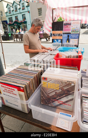 Un homme shopping de seconde main ou utilisé les disques vinyles dans un village market stall, Bridport Dorset, Angleterre, RU Banque D'Images