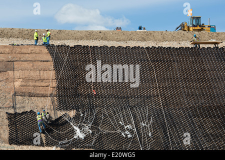 Stabiliser les travailleurs d'une colline dans le cadre de l'expansion d'une aire de sécurité de piste à Rocky Mountain Metro Airport. Banque D'Images