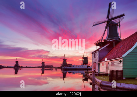 Moulins à vent hollandais traditionnel le long de la Zaanse Schans au lever du soleil Banque D'Images