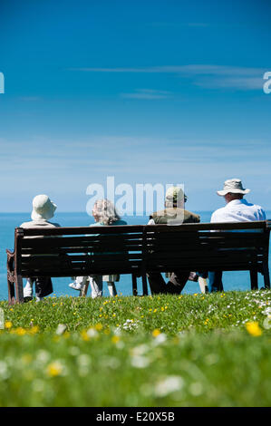 Pays de Galles Aberystwyth UK, le jeudi 12 juin 2014 avec des températures culminant à 18C (64F) sous un ciel bleu, un groupe de 4 personnes quatre hauts assis sur un banc, profitant de la météo en juin ensoleillé chaud Aberystwyth, sur la côte ouest du pays de Galles au Royaume-Uni. Les températures devraient augmenter de 2 à 3 degrés de nouveau demain, avant que davantage de temps incertain se déplace dans le week-end photo ©keith morris Banque D'Images