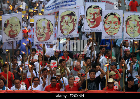 Manille, Philippines. 12 Juin, 2014. Maintenez les militants des torches et des pancartes lors d'un meeting de protestation contre le Fonds d'aide au développement prioritaire ou Scam Scam de l'assiette au beurre à Manille aux Philippines le 12 juin 2014. L'appel des militants pour l'emprisonnement de tous les hommes politiques impliqués dans le détournement de 10 milliards de pesos les fonds du gouvernement. Credit : Rouelle Umali/Xinhua/Alamy Live News Banque D'Images