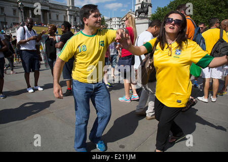 Londres, Royaume-Uni. Jeudi 12 juin 2014. Les Brésiliens se réunissent pour les célébrations du Jour du Brésil à Trafalgar Square. Un Rassemblement pour célébrer le début de la Coupe du Monde de la FIFA, Brésil 2014. Revelers chanter et danser et jouer jeux de football et tous les dans le jaune vert et bleu du drapeau brésilien. Crédit : Michael Kemp/Alamy Live News Banque D'Images