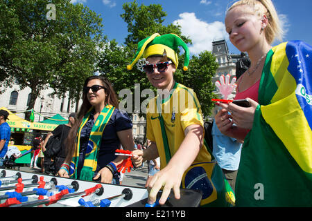 Londres, Royaume-Uni. Jeudi 12 juin 2014. Jouer au baby-foot. Les Brésiliens se réunissent pour les célébrations du Jour du Brésil à Trafalgar Square. Un Rassemblement pour célébrer le début de la Coupe du Monde de la FIFA, Brésil 2014. Revelers chanter et danser et jouer jeux de football et tous les dans le jaune vert et bleu du drapeau brésilien. Crédit : Michael Kemp/Alamy Live News Banque D'Images