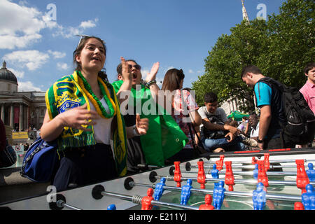 Londres, Royaume-Uni. Jeudi 12 juin 2014. Jouer au baby-foot. Les Brésiliens se réunissent pour les célébrations du Jour du Brésil à Trafalgar Square. Un Rassemblement pour célébrer le début de la Coupe du Monde de la FIFA, Brésil 2014. Revelers chanter et danser et jouer jeux de football et tous les dans le jaune vert et bleu du drapeau brésilien. Crédit : Michael Kemp/Alamy Live News Banque D'Images