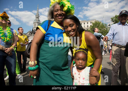 Londres, Royaume-Uni. Jeudi 12 juin 2014. Trois générations. Les Brésiliens se réunissent pour les célébrations du Jour du Brésil à Trafalgar Square. Un Rassemblement pour célébrer le début de la Coupe du Monde de la FIFA, Brésil 2014. Revelers chanter et danser et jouer jeux de football et tous les dans le jaune vert et bleu du drapeau brésilien. Crédit : Michael Kemp/Alamy Live News Banque D'Images