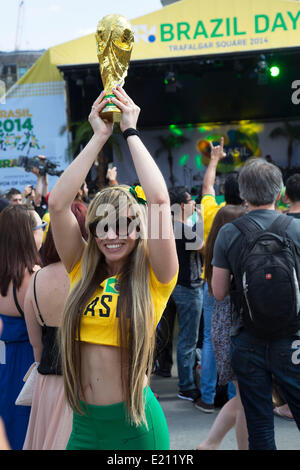 Londres, Royaume-Uni. Jeudi 12 juin 2014. Femme posant avec un trophée de la Coupe du monde. Les Brésiliens se réunissent pour les célébrations du Jour du Brésil à Trafalgar Square. Un Rassemblement pour célébrer le début de la Coupe du Monde de la FIFA, Brésil 2014. Revelers chanter et danser et jouer jeux de football et tous les dans le jaune vert et bleu du drapeau brésilien. Crédit : Michael Kemp/Alamy Live News Banque D'Images