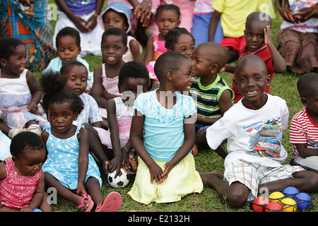 Un groupe de jeunes enfants orphelins assis dehors sur l'herbe, la Zambie, l'Afrique Banque D'Images