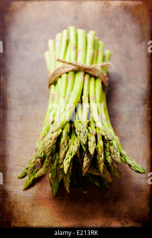 Bouquet d'asperges vertes fraîches sur planche de bois Banque D'Images