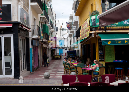 Les clients assis en sirotant un verre et déjeuner à l'extérieur d'un bar dans une rue à Ibiza Banque D'Images