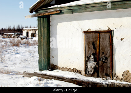 La neige a couvert la dégradation urbaine maison en bois porte cassée Banque D'Images