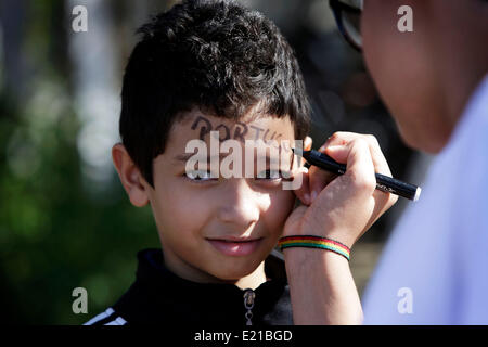 Campinas, São Paulo, Brésil. 11 Juin, 2014. Un garçon brésilien vous permet d'écrire sa mère dans son visage le mot 'Portugal' à l'aéroport de Viracopos Campinas, intérieur de Sao Paulo, Brésil, en attendant l'arrivée de l'équipe nationale de football portugais. Crédit : Bruno Colaco/ZUMA/ZUMAPRESS.com/Alamy fil Live News Banque D'Images