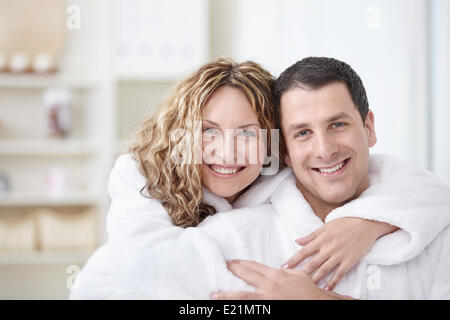 Young couple embracing in robes à la maison Banque D'Images