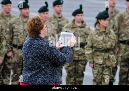 Femme utilise un iPad à la photographie ou la vidéo d'un défilé militaire Banque D'Images