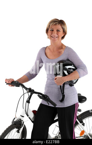 Blonde tout sourire avec le vélo Banque D'Images