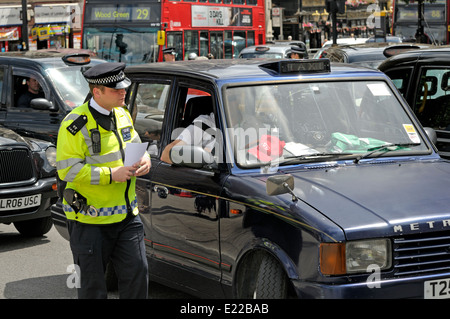 Londres, Angleterre, Royaume-Uni. Agent de police métropolitaine de parler à un chauffeur de taxi au cours d'une protestation des conducteurs dans le centre de Londres Banque D'Images