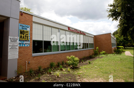 L'école secondaire avec des panneaux bilingues pas d'armes sur le terrain de l'école droit et une affiche prônant une l'école en tant que "pas de place pour la haine" Banque D'Images