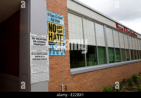 L'école secondaire avec des panneaux bilingues pas d'armes sur le terrain de l'école droit et une affiche prônant une l'école en tant que "pas de place pour la haine" Banque D'Images