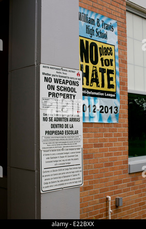 L'école secondaire avec des panneaux bilingues pas d'armes sur le terrain de l'école droit et une affiche prônant une l'école en tant que "pas de place pour la haine" Banque D'Images