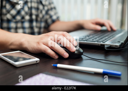 Mains d'homme blanc tenant une souris et l'impression sur un clavier Banque D'Images