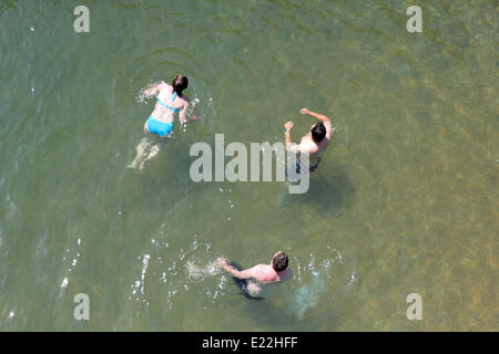 Brighton, Sussex. 13 juin 2014. Ces trois personnes vous rafraîchir avec une baignade dans la mer près de la jetée de Brighton, le de soleil ciel bleu et les températures atteignent 24 degrés celsius sur la côte sud. Credit : Julia Gavin/Alamy Live News Banque D'Images