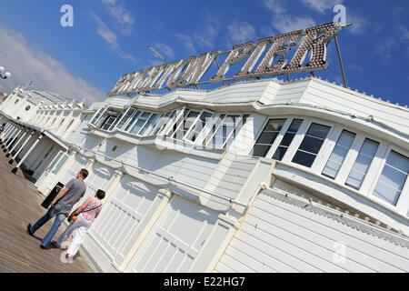 Brighton, Sussex. 13 juin 2014. Un couple en train de marcher sur la jetée de Brighton, le de soleil ciel bleu et les températures atteignent 24 degrés celsius sur la côte sud. Credit : Julia Gavin/Alamy Live News Banque D'Images