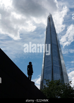 Grand angle de Londres contre un fragment bleu dramatique et d'aéronefs et ciel blanc avec sillhoutted sculpture de femme en premier plan Banque D'Images