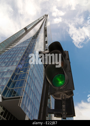Un grand angle de l'Écharde de Londres contre un ciel bleu et blanc avec feu de circulation en premier plan montrant le vert pour les rendez-vous Banque D'Images