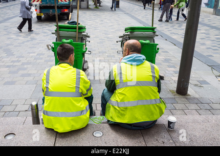 Deux travailleurs du conseil qui ne le balayage des rues, avoir une pause-café. Sauchiehall Street, Glasgow, Scotland, UK Banque D'Images