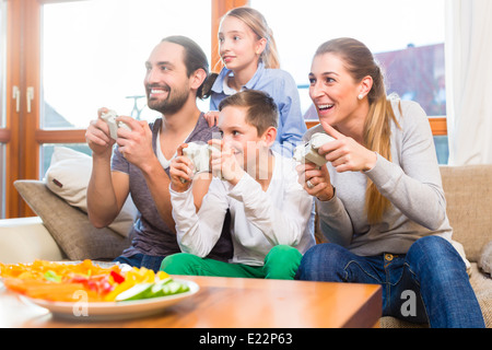 Ayant de la famille temps libre ensemble et jouer avec une console de jeux vidéo Banque D'Images