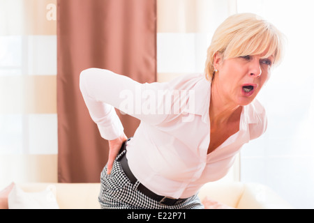 Old woman holding en raison d'une lombalgie Banque D'Images
