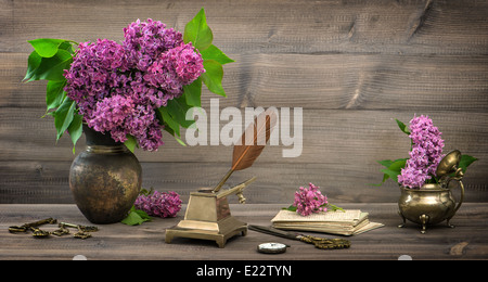 Nature morte avec fleurs lilas et meubles anciens articles écrit sur fond de bois. retro toned photo Banque D'Images