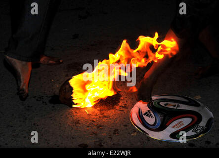 Solo, en Indonésie. 14 Juin, 2014. SOLO, le centre de Java, INDONÉSIE - JUIN 12 : Indonesian Men playing football fire .Â pendant l'attente pour l'ouverture de la Coupe du Monde de la FIFA, brésil 2014, en solo, le centre de Java, en Indonésie, le 12 juin. Fire est un jeu de football joué avec une boule de feu de coco, imbibé de kérosène en feu. © Agoes Rudianto/NurPhoto ZUMAPRESS.com/Alamy/Live News Banque D'Images