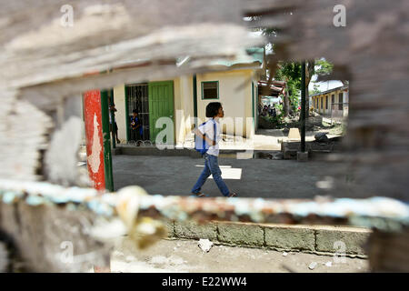 11 juin 2014 - Tacloban, Philippines - un élève est vu en passant devant une vitrine endommagée à San Jose Central School, Tacloban City le 11 juin 2014. Le 8 novembre 2013, Haiyan, l'un des plus puissant typhon à jamais frappé la terre, ravagé les Visayas orientales des milliers de morts et de sans-abri. Le gouvernement estime à 16 millions de personnes ont été touchées par le typhon, avec 6 300 morts et des milliers d'autres portés disparus. Logement et subsistance sont parmi les graves défis dans le processus de réadaptation dans les régions touchées par Haiyan sept mois après la catastrophe. (Crédit Image : © Mark Cristino/NurPho Banque D'Images