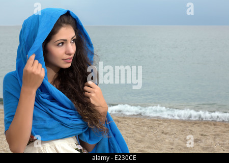 Belle jeune femme avec de longs cheveux noirs enveloppés dans un foulard bleu Banque D'Images