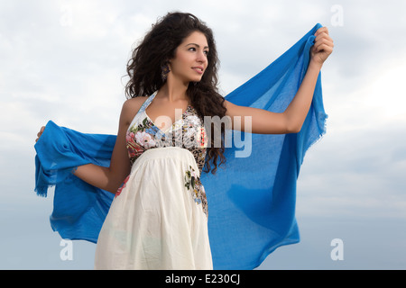 Belle jeune femme avec de longs cheveux noirs enveloppés dans un foulard bleu Banque D'Images