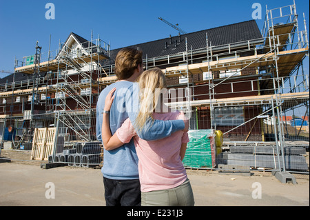 Jeune couple à la recherche de maisons nouvellement construites on construction site Banque D'Images