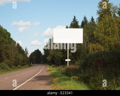 Blank billboard sur route vide en passant par la forêt. Banque D'Images