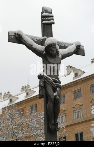 Crucifix en bronze recouvert de neige à l'Lazebnicky Pont sur la Vltava à Cesky Krumlov, République tchèque, la Bohême du Sud. Banque D'Images