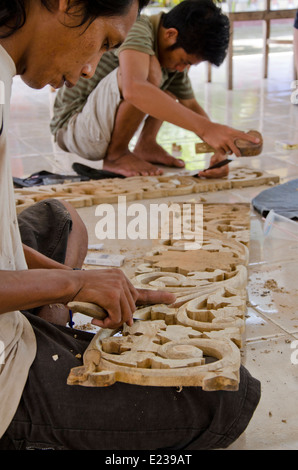 L'Indonésie, l'île de Lombok, Gunnungsari. Sesela Marché de l'art. Démonstration de sculpture sur bois d'experts. Banque D'Images